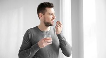 o homem está tomando remédios para tratamento de prostatite